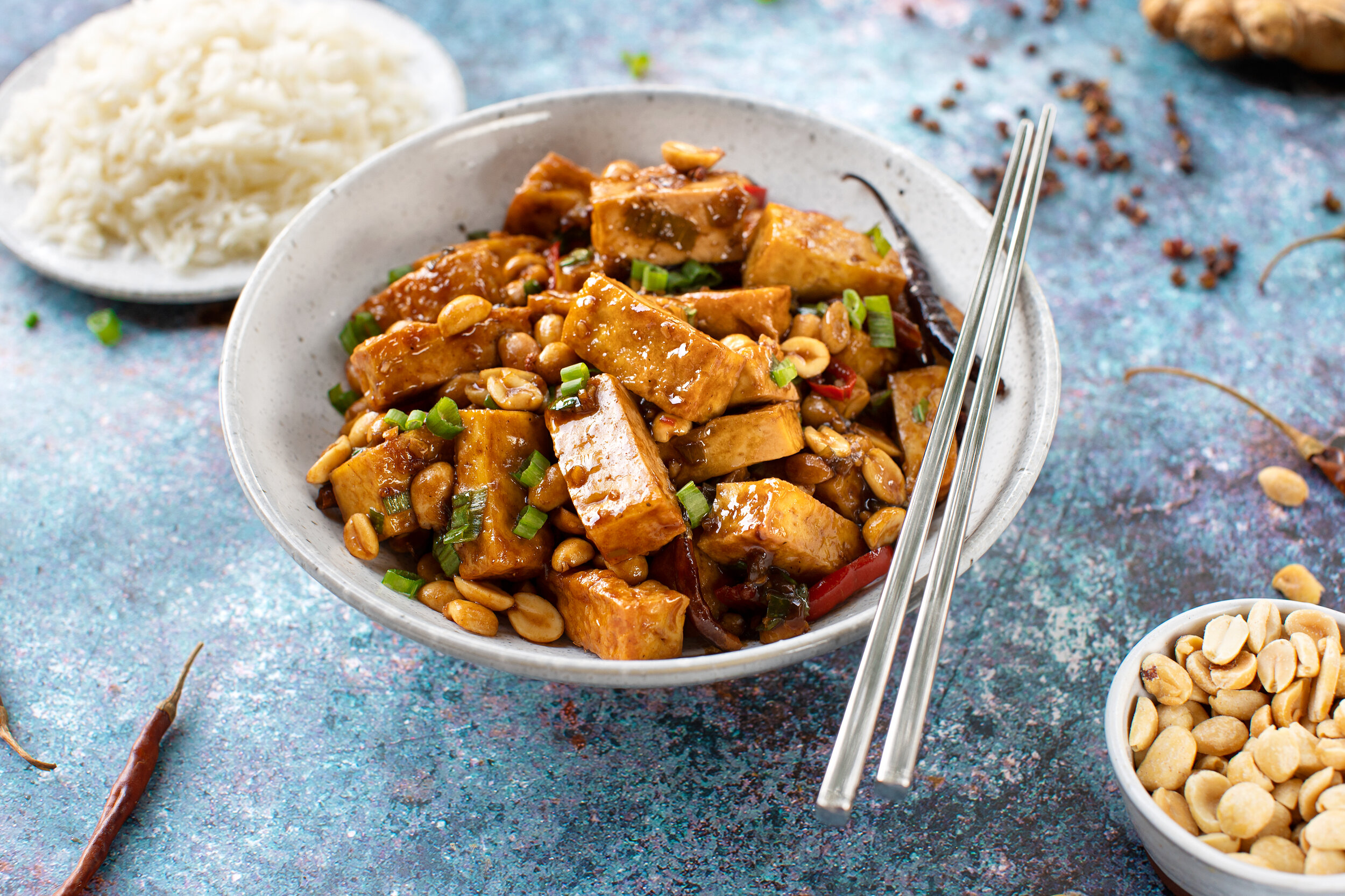 A bowl of Hodo Foods' Kung Pao Tofu recipe with rice and peanuts on the side.