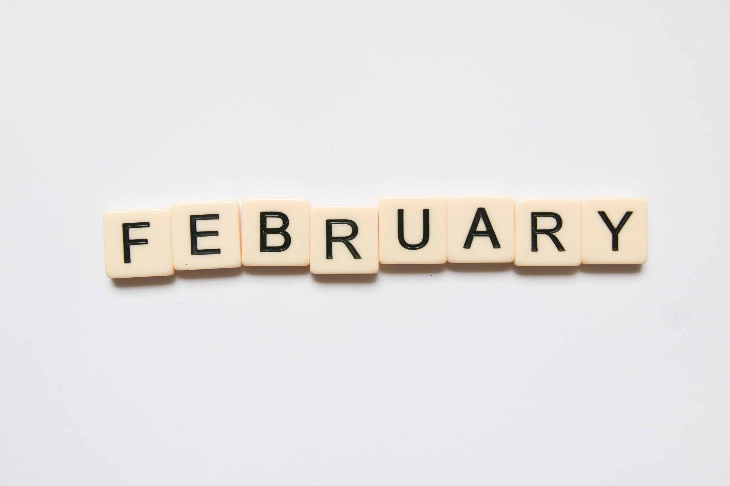 february spelled out with scrabble tiles